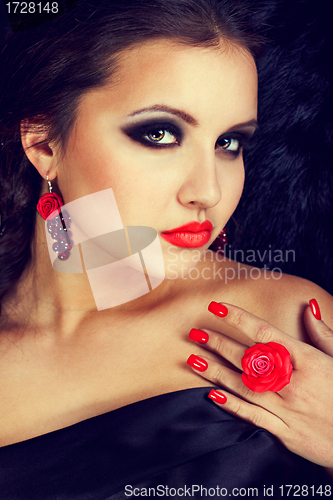 Image of Young beautiful woman with rose in finger