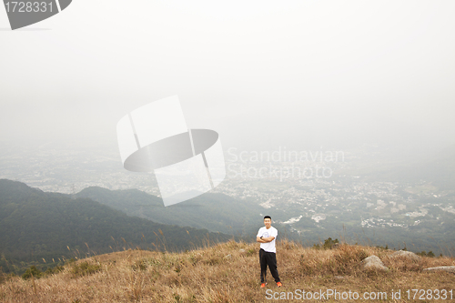 Image of Asian man hiking in mountains