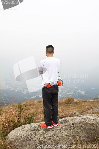 Image of Asian man hiking in mountains