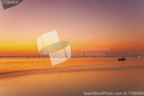 Image of Sunset along the coast with bridge background