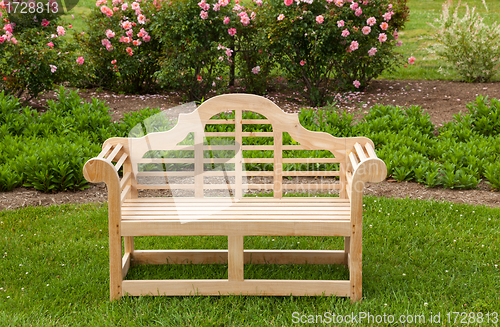Image of Teak chair or bench on green lawn