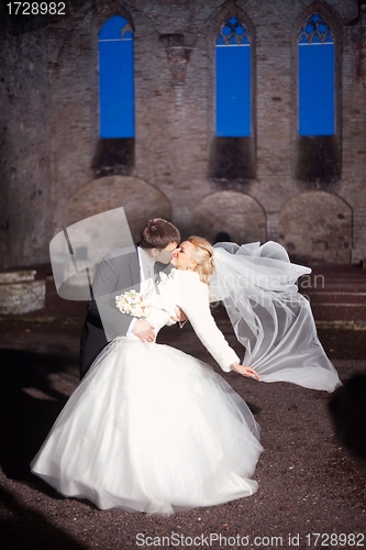 Image of groom and the bride in stone court yard of castle