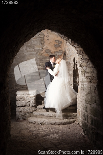 Image of groom and the bride in interior of medieval castle