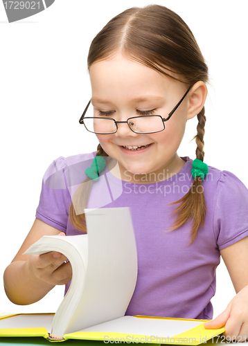 Image of Cute cheerful little girl with book