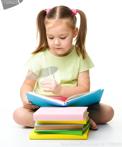 Image of Cute little girl reads a book