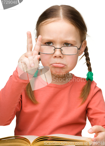 Image of Sad little girl showing "Victory" gesture