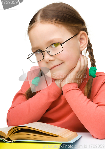 Image of Cute cheerful little girl with book
