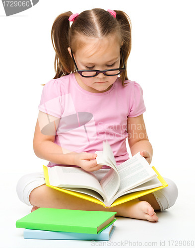 Image of Cute little girl reads a book