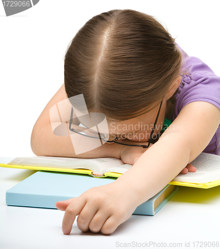 Image of Cute little girl is sleeping on a book