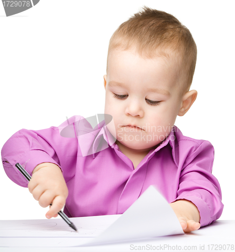 Image of Cute little boy is drawing with pen