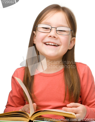 Image of Cute cheerful little girl with book