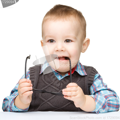 Image of Cute little child biting glasses