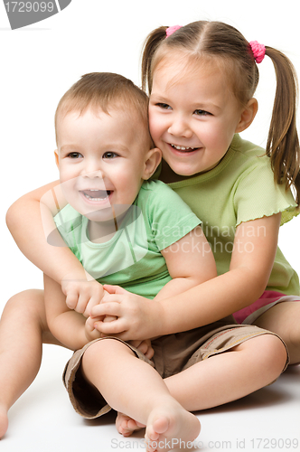 Image of Two children are having fun while sitting on floor