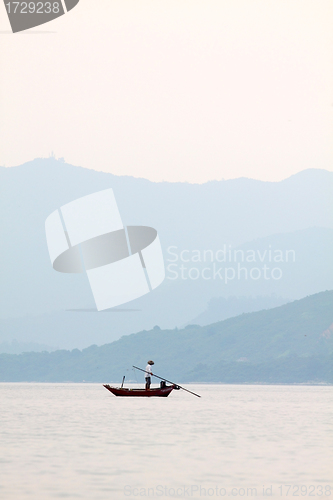 Image of Fisherman over the ocean and between the mountain ridges