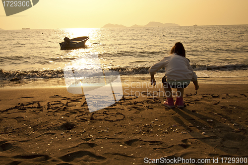 Image of Asian children drawing on sand