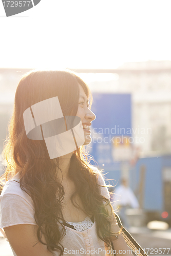 Image of Asian woman similing under sunlight