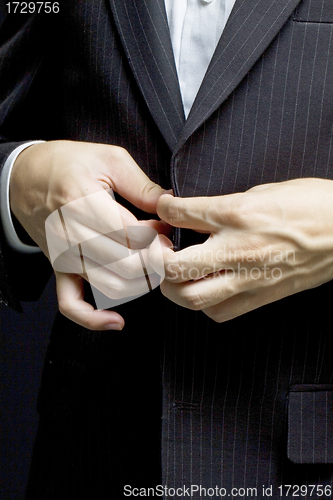 Image of Business man tidy up his suit's button
