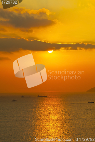 Image of Sunset over the ocean with moving ships