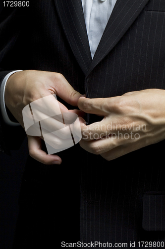 Image of Business man tidy up his suit's button