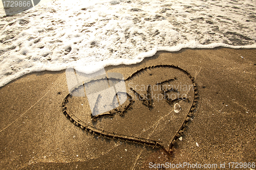 Image of Love concept handwritten on sand