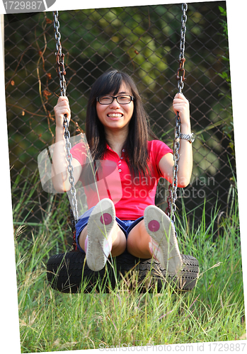 Image of Asian woman playing swing with happy face