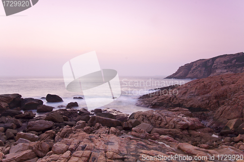 Image of Sunrise along seashore under long exposure