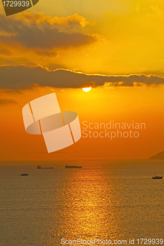 Image of Sunset over the ocean with moving ships