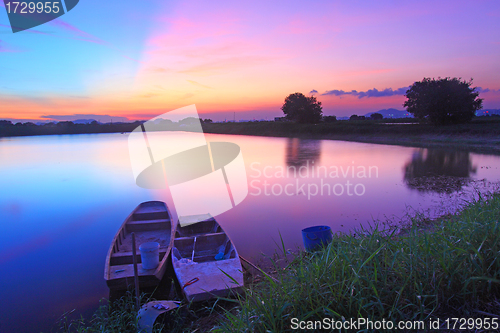 Image of Isolated boats along the pond at sunset time