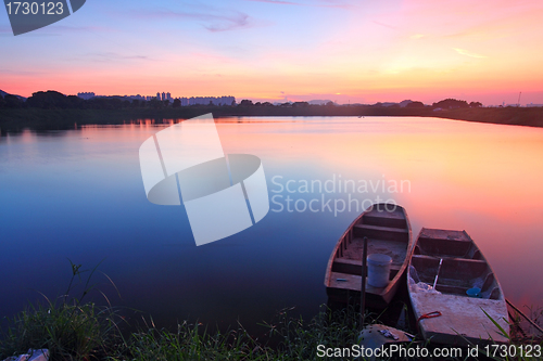 Image of Sunset along the pond with isolated boats