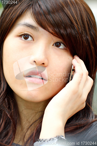 Image of Asian woman talking on phone with curious face
