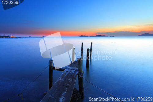 Image of Sunset at dusk along a wooden pier, high saturation image.