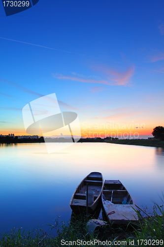 Image of Sunset along the pond with two boats