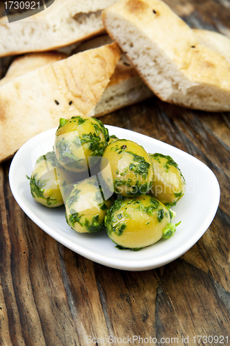 Image of green olives with fresh bread and herbs