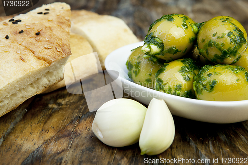 Image of green olives with fresh bread and herbs