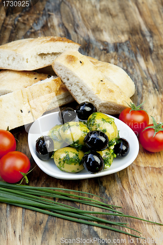 Image of green olives with fresh bread and herbs