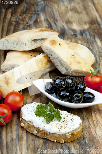 Image of green olives with fresh bread and herbs