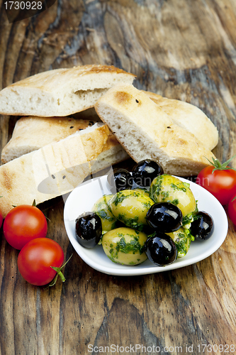 Image of green olives with fresh bread and herbs