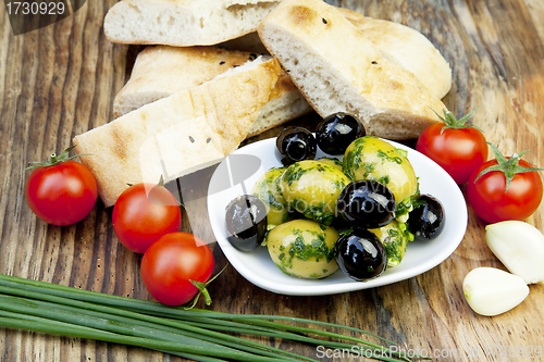 Image of green olives with fresh bread and herbs