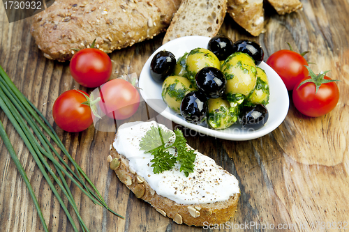 Image of green olives with fresh bread and herbs