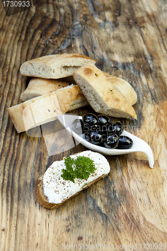 Image of green olives with fresh bread and herbs