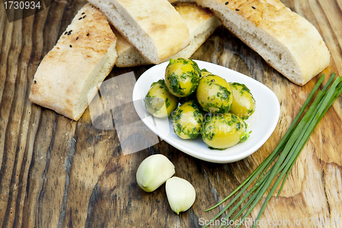 Image of green olives with fresh bread and herbs