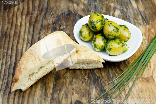 Image of green olives with fresh bread and herbs