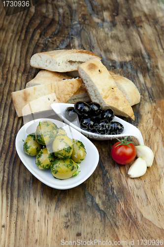 Image of green olives with fresh bread and herbs