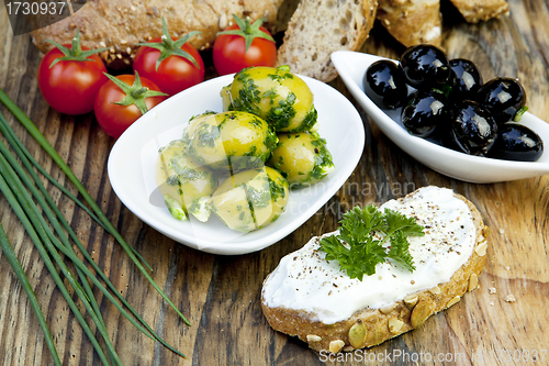 Image of green olives with fresh bread and herbs