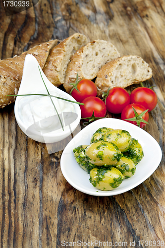Image of green olives with fresh bread and herbs