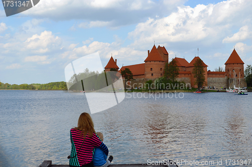 Image of Mother hug son sit on bridge front Trakai Castle 