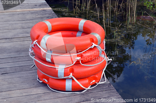 Image of Life savers buoys orange stack wooden lake pier 