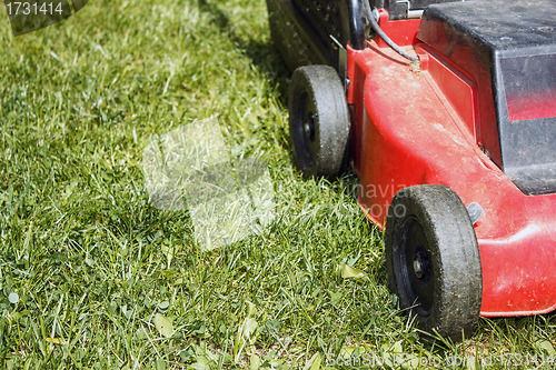 Image of detail of lawnmower on green grass