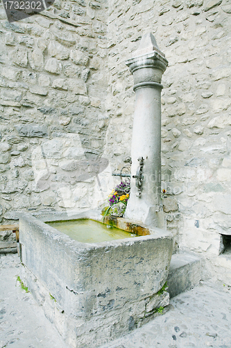 Image of old stone fountain with watering in Chateau Chiilon, Montreux, S