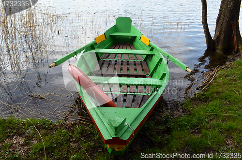 Image of Rowing wooden boat on lake shore and resque circle 